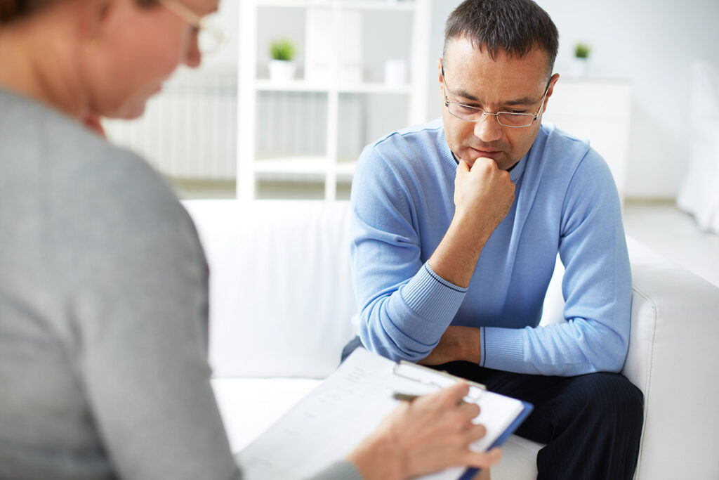 Man learning about Adderall abuse long-term effects from therapist