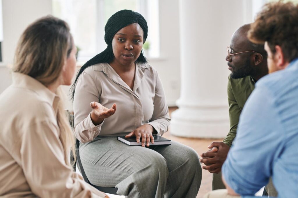 People sitting in a circle at a group therapy session