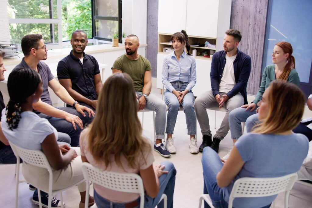 People sitting in a circle at a group therapy session