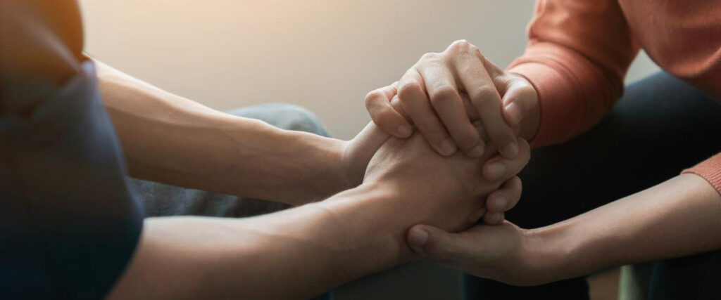 Hands of two people talking at an addiction treatment program session in Colorado
